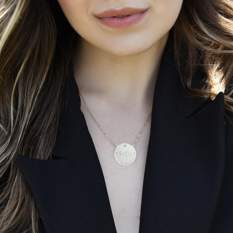 A necklace for a woman with a round pendant in the shape of a large coin and the possibility of engraving on it