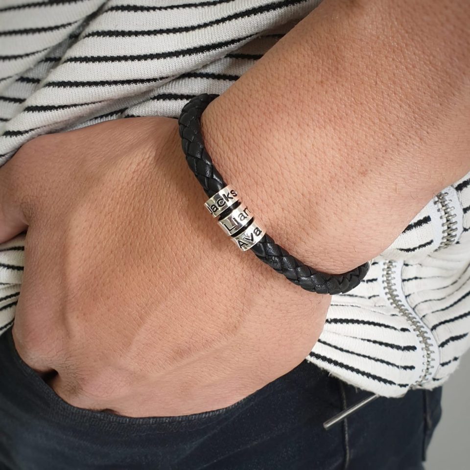 A leather bracelet combined with charms and engraved names on beads