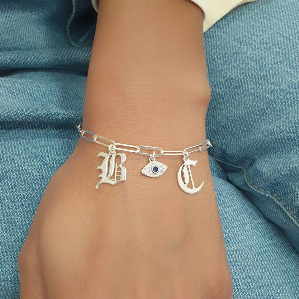 A thick link bracelet for a woman with a choice of letter pendants in Gothic font and an eye element