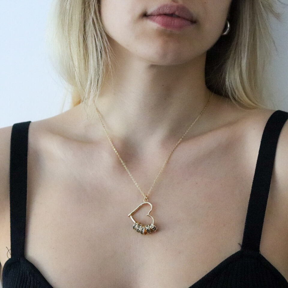 Women's gold-colored necklace with a heart pendant and engraved beads with the children's names inside