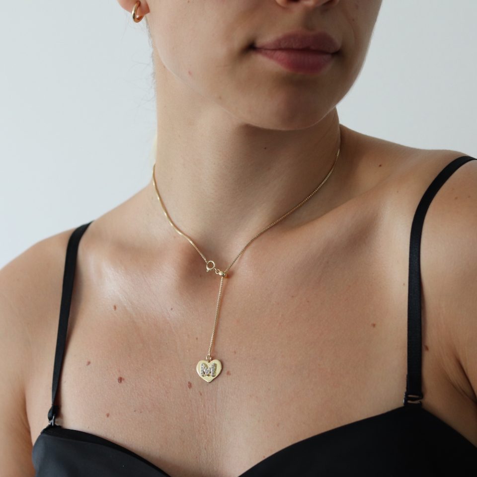 A necklace with inlaid letter heart pendant in gold