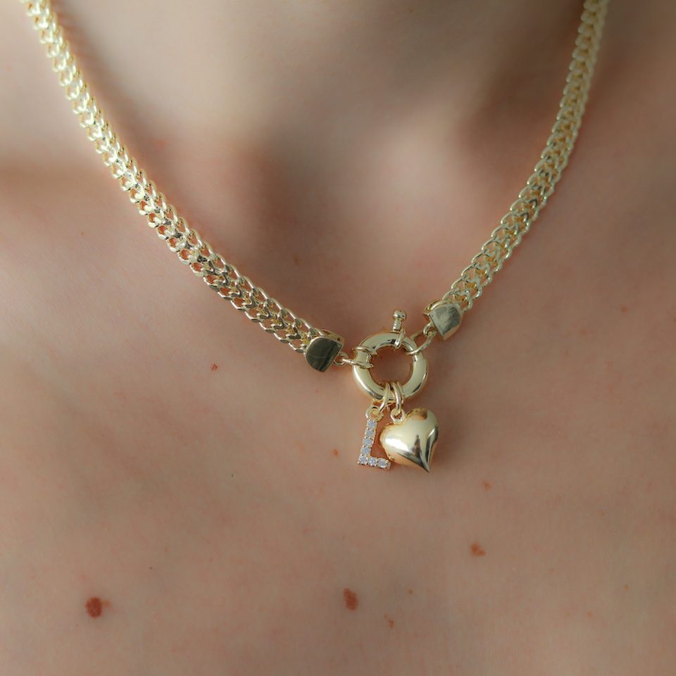 A gold necklace with Puffy heart pendant with letter