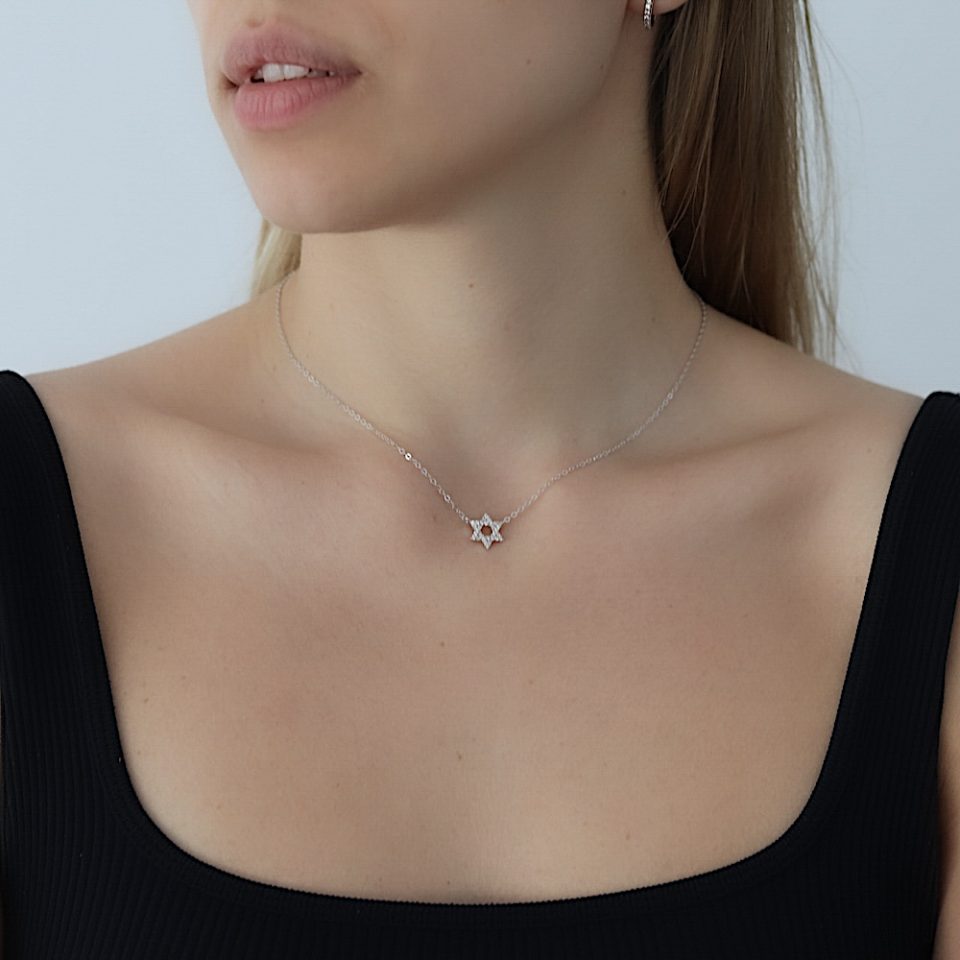 A necklace with a delicate and inlaid small Star of David pendant