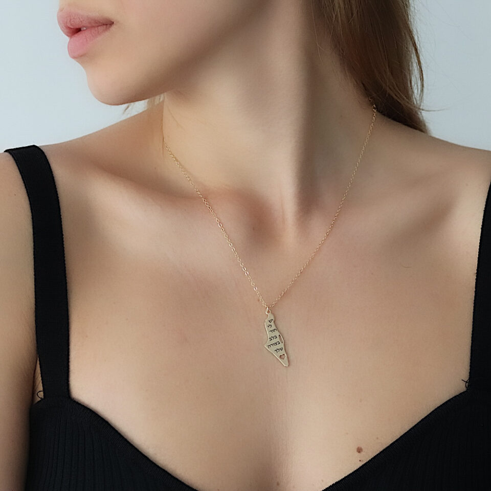 A gold-plated map of the Land of Israel necklace on a hollow heart and engraved text